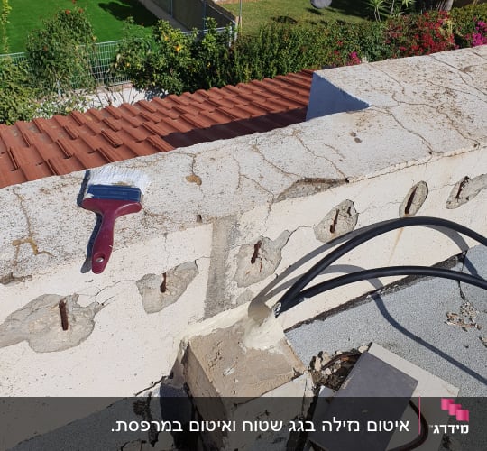 מברשת צבע על קיר עם סדקים ותיקוני איטום